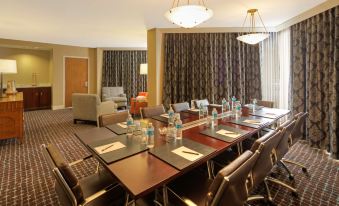 a large conference room with a long wooden table and multiple chairs arranged around it at Hilton Houston Westchase