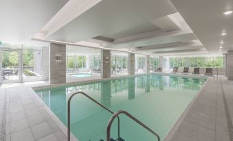 a large indoor swimming pool with multiple lanes and clear water , surrounded by white walls and windows at Residence Inn Halifax Dartmouth