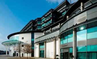 "a large building with a green sign that says "" calbert "" on it , surrounded by trees" at London Twickenham Stadium Hotel, a Member of Radisson Individuals