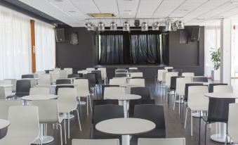 a large , empty conference room with multiple tables and chairs , ready for a meeting or event at Globales Cala Blanca