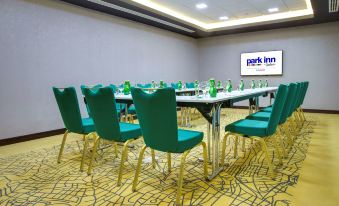 a conference room with a long table and chairs , set up for a meeting or presentation at Park Inn by Radisson Dammam