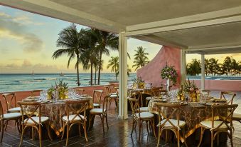 The restaurant offers ocean views from its beachfront dining room, complete with tables and chairs at The Royal Hawaiian, A Luxury Collection Resort, Waikiki