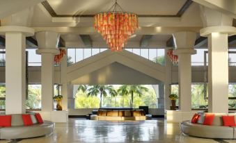 a hotel lobby with a large chandelier hanging from the ceiling , creating a warm and inviting atmosphere at Thistle Port Dickson Resort