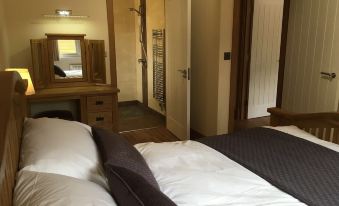 a hotel room with two beds , one on the left and one on the right side of the room at Shellow Lane Lodges
