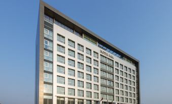 a tall building with many windows is located on a street corner near a street at Hotel Baia