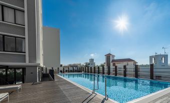 a rooftop pool surrounded by a wooden deck , with a sunny day and clear blue sky in the background at Hyatt Regency Naha, Okinawa