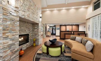 a large , modern hotel lobby with a fireplace , couches , and a tv . also a dining table in the room at Homewood Suites by Hilton Columbus - Hilliard