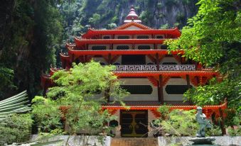 a traditional chinese temple nestled in a lush green forest , with its red roof and yellow stairs leading up to it at Z Hotel