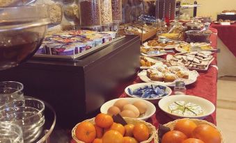 a buffet table filled with a variety of food items , including fruits , pastries , and beverages at Hotel Joli