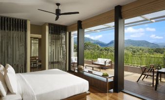 a spacious bedroom with a large bed and a view of mountains outside the window at Jetwing Lake