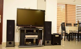 a living room with a large flat - screen tv mounted on the wall , surrounded by various electronic devices at Click to Go