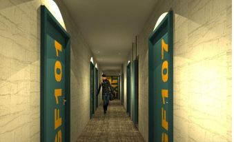 a person is walking down a hallway with green doors and yellow letters on them at The Garrison