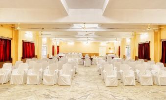 a large , empty banquet hall with white chairs and tables set up for a formal event at Hotel Empire