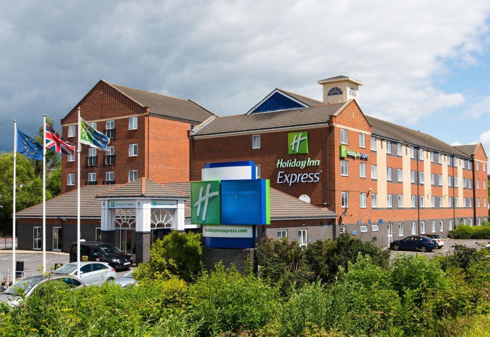 "a large hotel with a green and blue sign that reads "" holiday inn express "" prominently displayed on the front of the building" at Holiday Inn Express Newcastle Gateshead