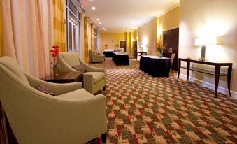 a hotel lobby with several couches and chairs arranged for guests to relax and socialize at Holiday Inn Statesboro-University Area