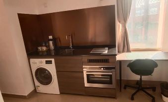There is an apartment with a kitchen that includes a sink, stove, and washing machine all in one room at Grand Harbour Hotel