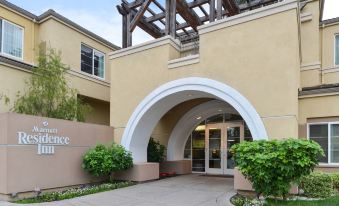 a modern building with an arched entrance , surrounded by lush greenery and a clear blue sky at Residence Inn Palo Alto Los Altos