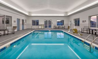 an indoor swimming pool with a blue tiled floor , surrounded by white walls and ceiling at Staybridge Suites Pittsburgh Airport