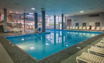 an indoor swimming pool surrounded by chairs and tables , providing a relaxing atmosphere for guests at Best Western Plus Strongsville Cleveland