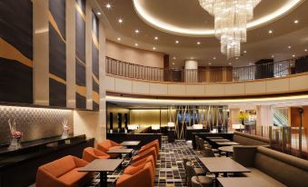 a modern hotel lobby with various seating options , including couches and chairs , as well as a dining area at Hotel Metropolitan Yamagata