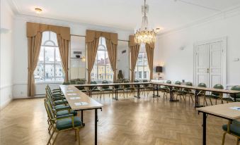a large , well - lit room with a wooden floor and multiple tables set up for an event at Vimmerby Stadshotell, WorldHotels Crafted