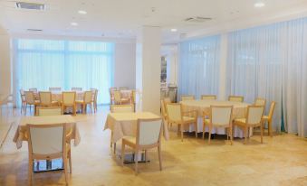 a large dining room with multiple tables and chairs arranged for a group of people at Nautilus