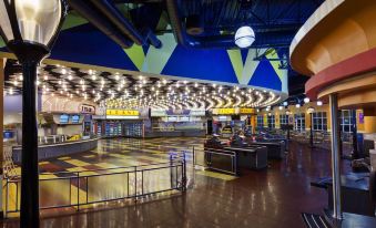 an empty shopping mall with a large ceiling and several people waiting in line to purchase merchandise at Disney's All-Star Movies Resort