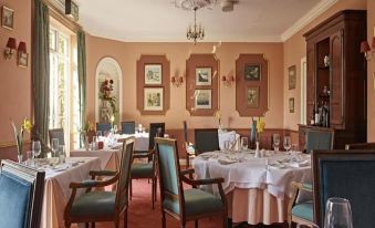 a large dining room with multiple tables and chairs arranged for a group of people to enjoy a meal together at Corse Lawn House Hotel