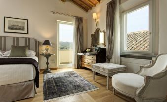 a modern bedroom with wooden floors , white walls , and large windows offering views of the outdoors at Villa le Calvane
