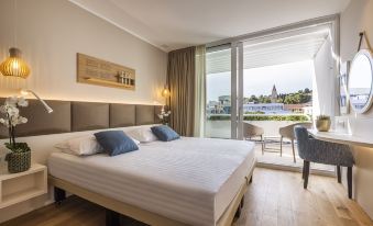 a hotel room with a large bed and a balcony overlooking the ocean , creating a serene and inviting atmosphere at Hotel Histrion