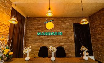 "a reception area with a large neon sign reading "" mandarin "" and a yellow lemon hanging above it" at Mandarin