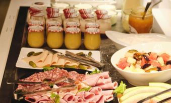 a buffet table filled with a variety of food items , including fruits , meats , and drinks at Mercure Chartres Cathedrale