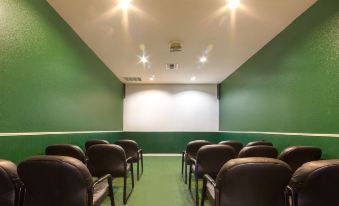 a green - tiled room with rows of black leather chairs facing a white screen , and two spotlights on the ceiling at Holiday Inn Club Vacations Villages Resort Lake Palestine