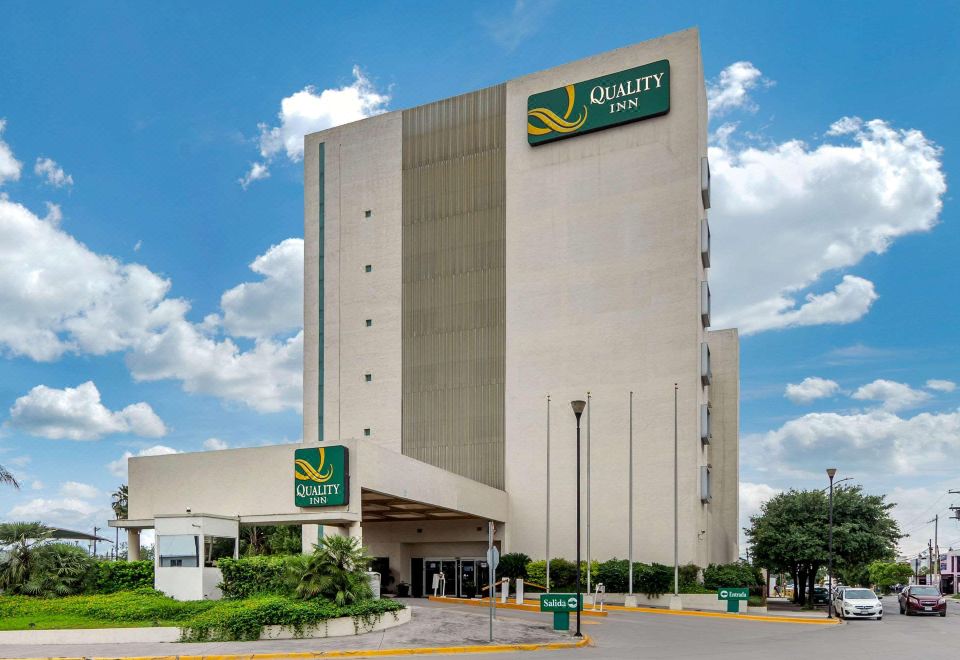"a large hotel building with a green sign that reads "" quality inn "" prominently displayed on the front" at Quality Inn Monterrey la Fe
