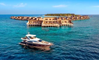 an aerial view of a luxury yacht floating on a body of water near a resort , surrounded by crystal - clear blue water at The St. Regis Maldives Vommuli Resort