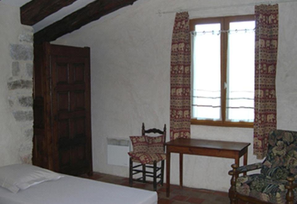 a room with two beds , one on the left side and the other on the right side of the room at La Bergerie