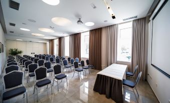 a conference room with rows of chairs arranged in a semicircle , and a podium at the front at Hotel Continental