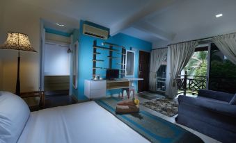 a bedroom with a blue and white color scheme , featuring a bed , desk , and chair at Paya Beach Spa & Dive Resort