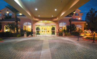 a large building with a brick courtyard in front of it , surrounded by trees and other structures at Hilton Garden Inn Las Vegas Strip South