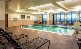 a large indoor pool surrounded by lounge chairs , where people are relaxing and enjoying their time at Hilton Garden Inn Uniontown