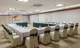 a large conference room set up for a meeting , with tables and chairs arranged in a semicircle at Amani Tiwi Beach Resort