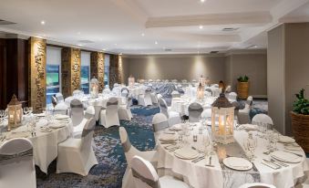 a well - decorated banquet hall with numerous dining tables and chairs arranged for a wedding or special event at Crowne Plaza Stratford Upon Avon