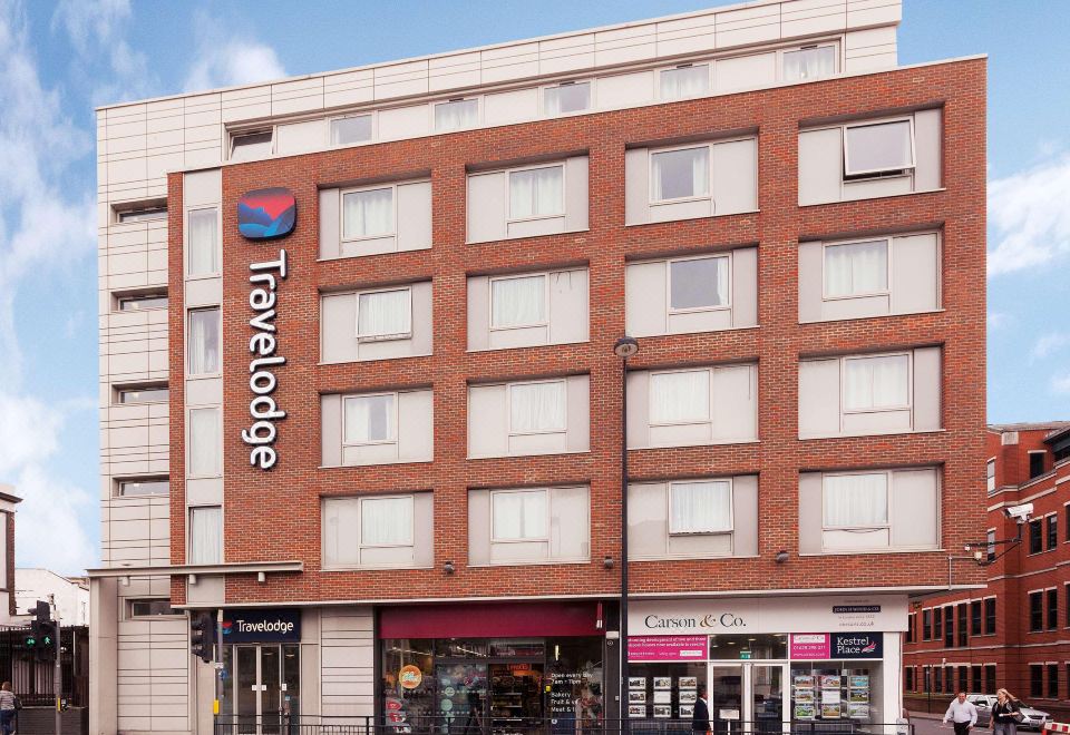 "a large building with a red brick exterior and the words "" travelodge "" written in blue" at Travelodge Maidenhead Central