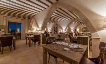 a restaurant with a dining area and a bar , featuring a wooden table and chairs at Hotel Creu de Tau Art&Spa-Adults Only