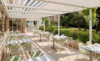 an outdoor dining area at a hotel , with tables and chairs arranged for guests to enjoy their meal at Valamar Meteor Hotel