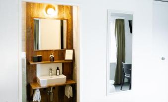 a bathroom with a wooden shelf and sink , white towels hanging on the side , and a window at Alpenblick Weggis - Panorama & Alpen Chic Hotel