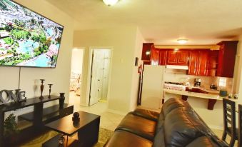 a living room with a large flat - screen tv mounted on the wall , a couch , and a dining table at Villa Del Sol