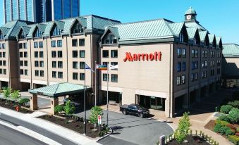 a marriott hotel with a large sign on the side of the building , surrounded by cars and trees at Halifax Marriott Harbourfront Hotel