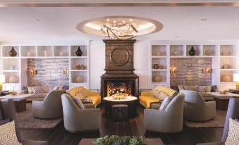a modern living room with a large stone fireplace , comfortable seating arrangements , and a dining table at The Ritz-Carlton, Marina del Rey