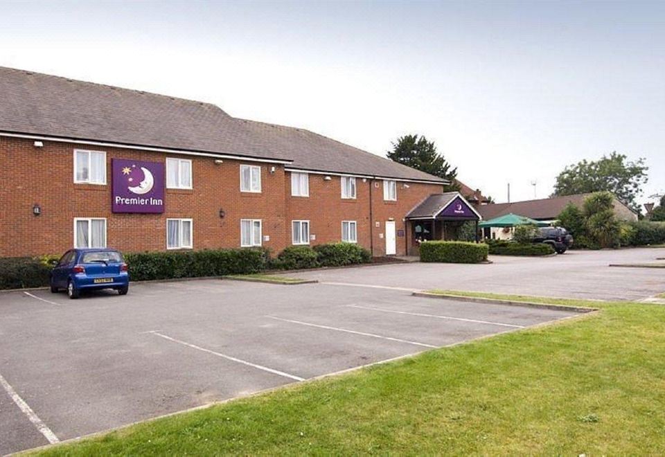 "a red brick building with a purple sign that reads "" premier inn "" prominently displayed on the front of the building" at Swindon North